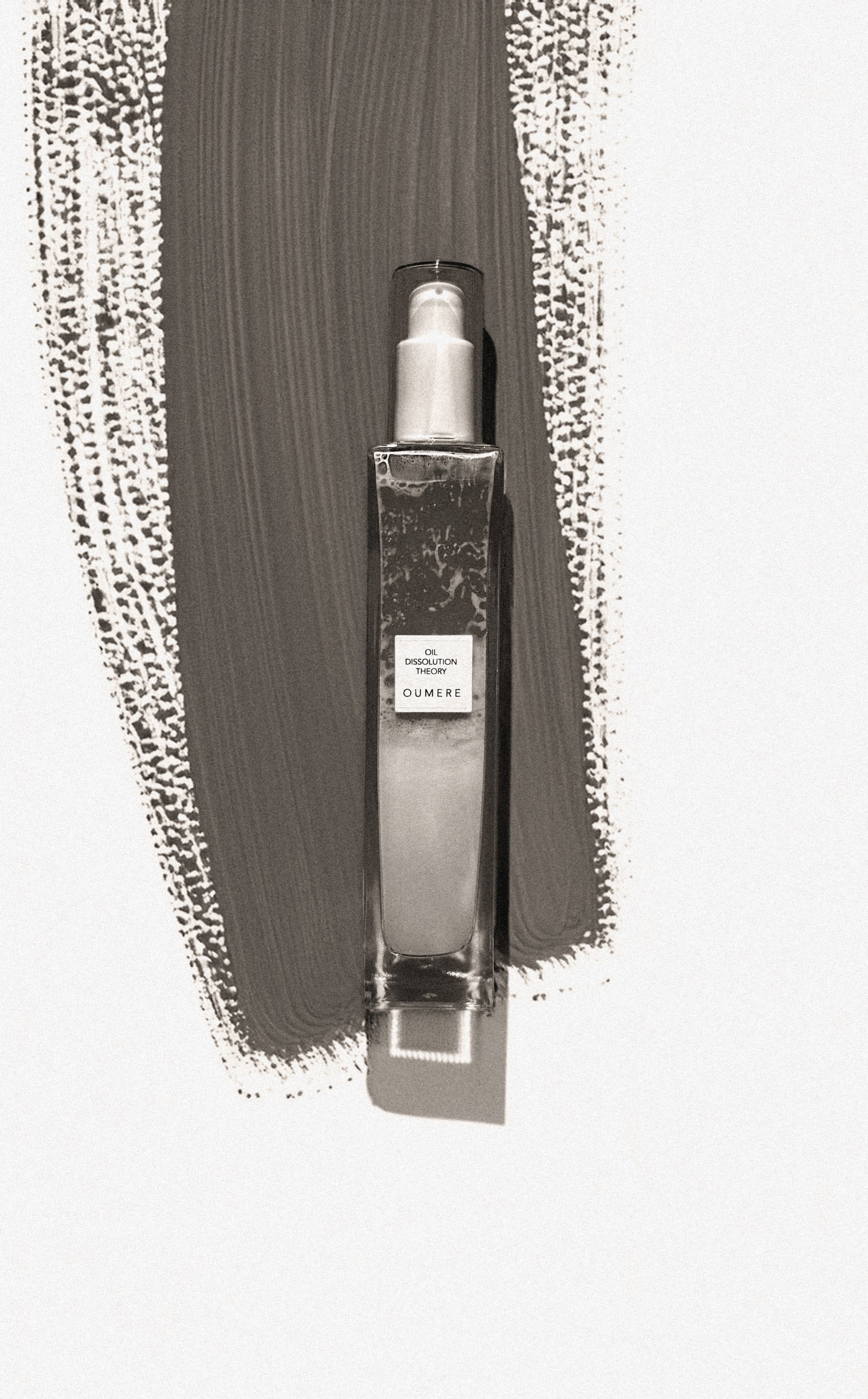 Clear spray bottle with label on a textured gray background