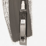 Clear spray bottle with label on a textured gray background