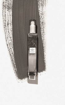 Clear spray bottle with label on a textured gray background